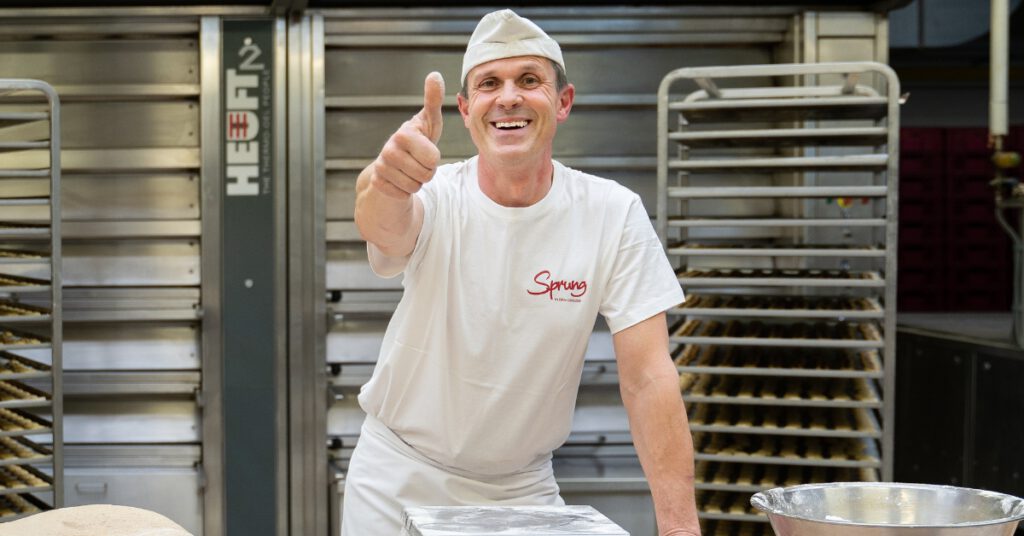 Motivierter Bäcker bei der Teigvorbereitung in der Backstube der Bäckerei Sprung